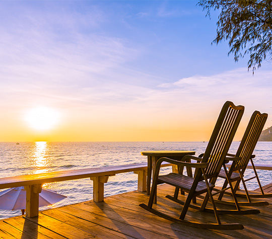 chairs on deck facing sun setting over water guaranteed income oregon