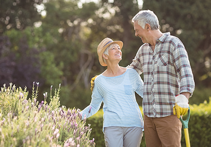 couple smiling at each other while gardening life insurance for retirement oregon