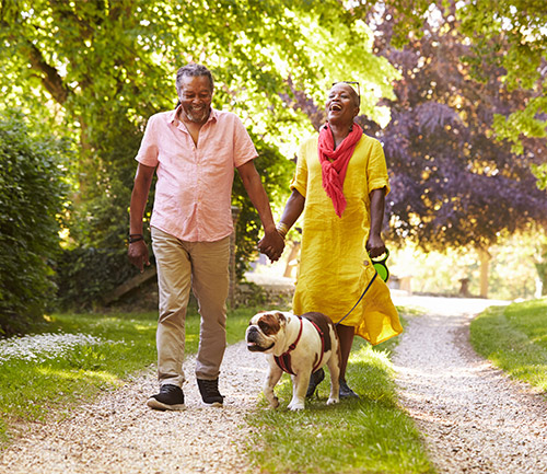 happy couple walking dog in park understanding reasonable rates of return vancouver wa