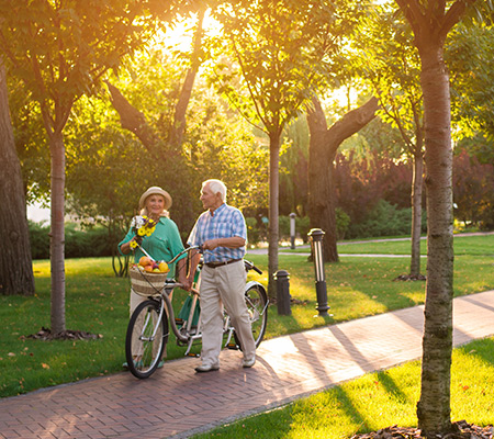 senior couple walking beside bicylcle in the park benefits of an annuity vancouver wa