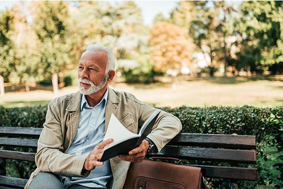 senior man sitting on bench with book fixed index annuities oregon